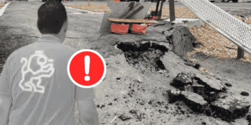 Person Standing Near a Large Sinkhole in a Street with a Red Warning Exclamation Icon on the Foreground. - Regio Politica